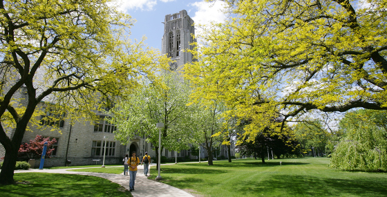 A student walking by University Hall in the spring