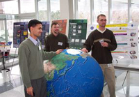 Students in the geography program standing in a lab near a globe