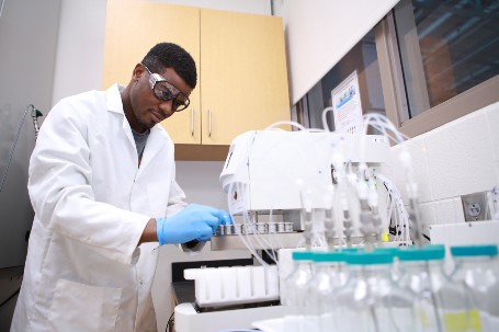 student in lab coat in lab