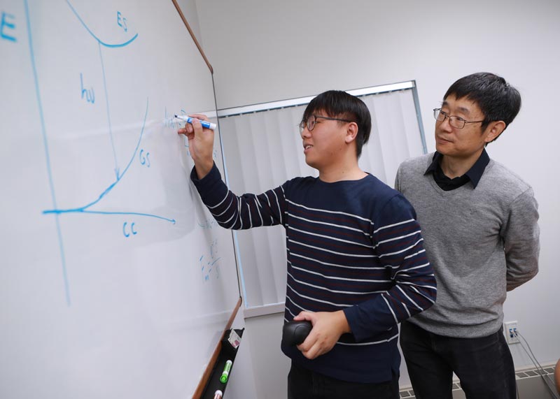 Dr. Yan working with a student on a formula
