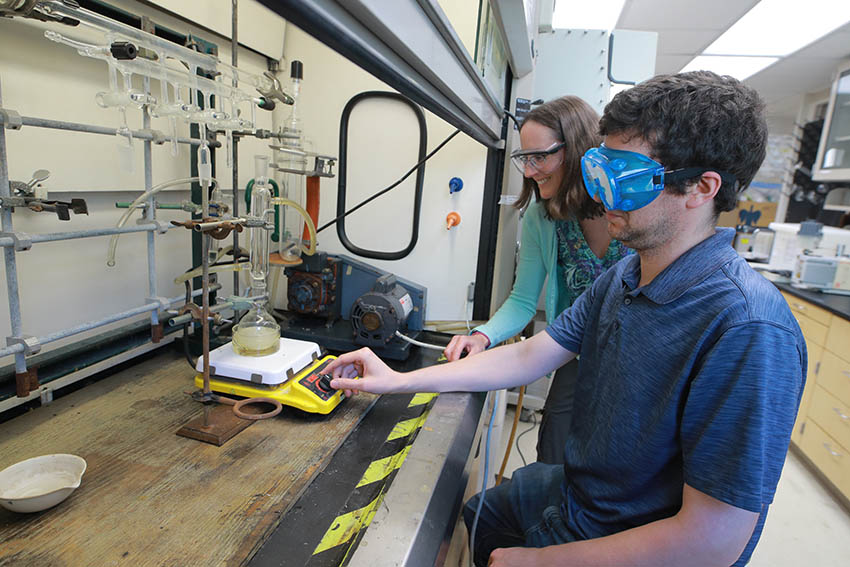 Dr. Cora Lind-Kovacs and Brandon Russell adjust the temperature on a reflux reaction to produce a model expander molecule