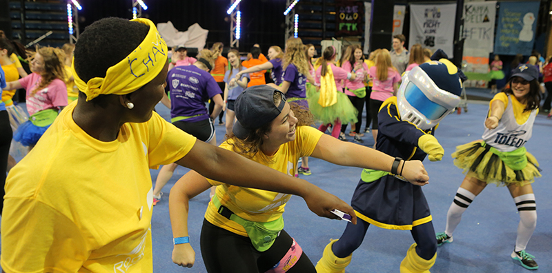students dancing with rocksy at an event