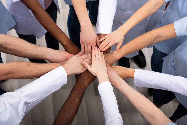 image of group of people in a circle with hands united in the middle