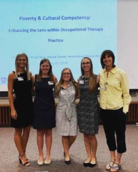Dr. Laura Schmelzer with OTD students standing in front of Capstone Presentation