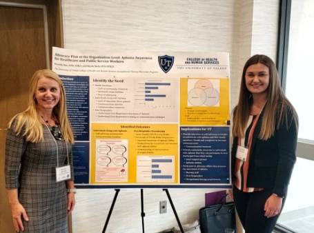 OTD clinical associate professor and OTD student presenting research poster