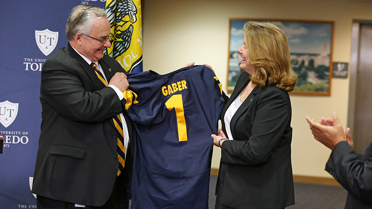 Dr. Gaber holding up a UT football jersey