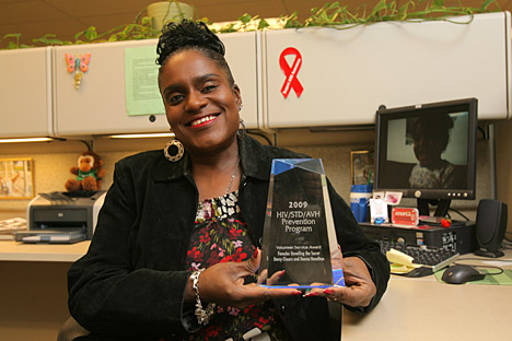 Darcy Chears holding HIV Volunteer Service Award