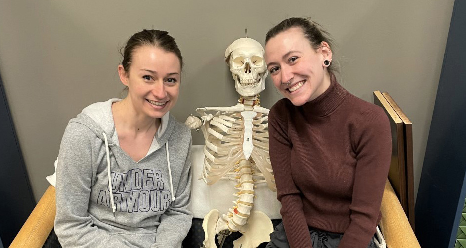 Students pose for a photo with a skeleton model