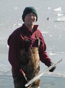 Ecology student collects aquatic samples through the ice at Lake Erie Center