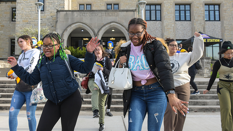 students dancing to music in front of student union