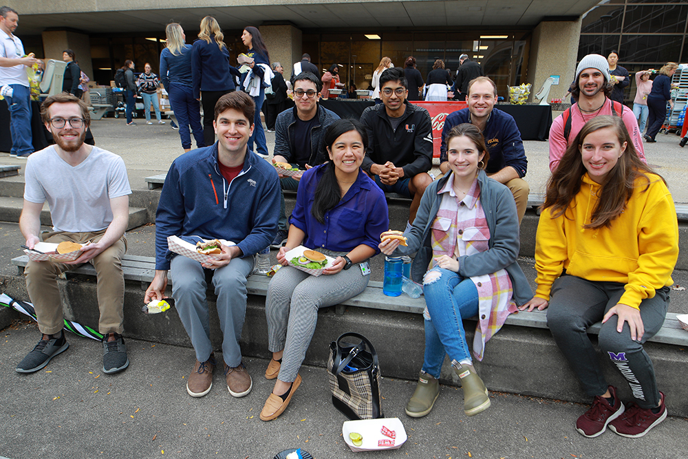 A group of students on the Health Science campus eat lunch together at the Founder's Day BBQ