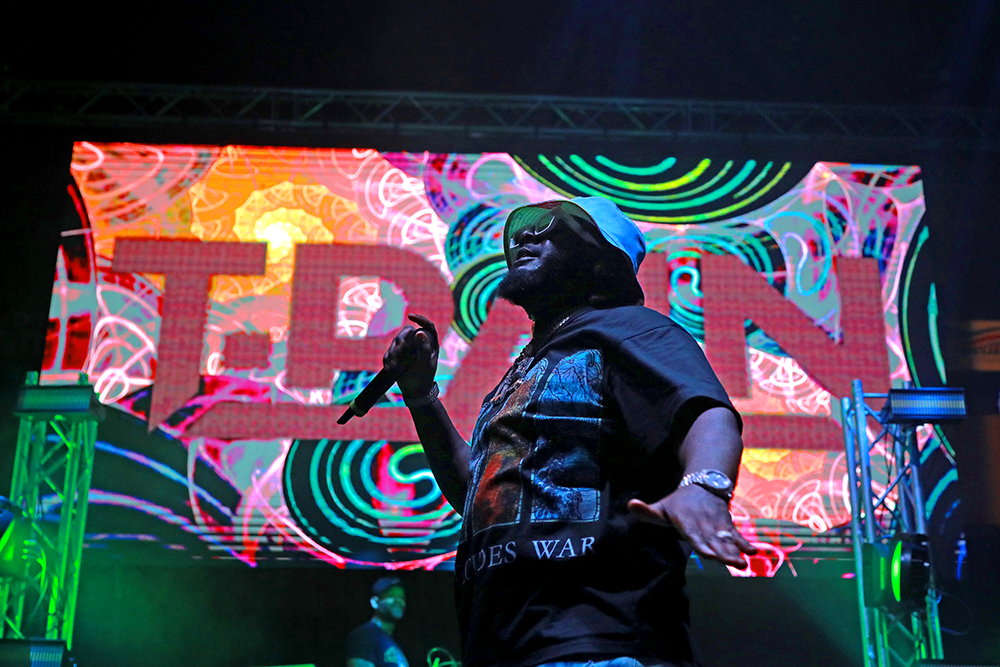 Rapper T-Pain performs against a colorful screen at the Founder's Day Concert