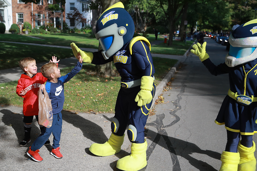 Rocky and Rocksy interact with two young spectators at the Homecoming Parade