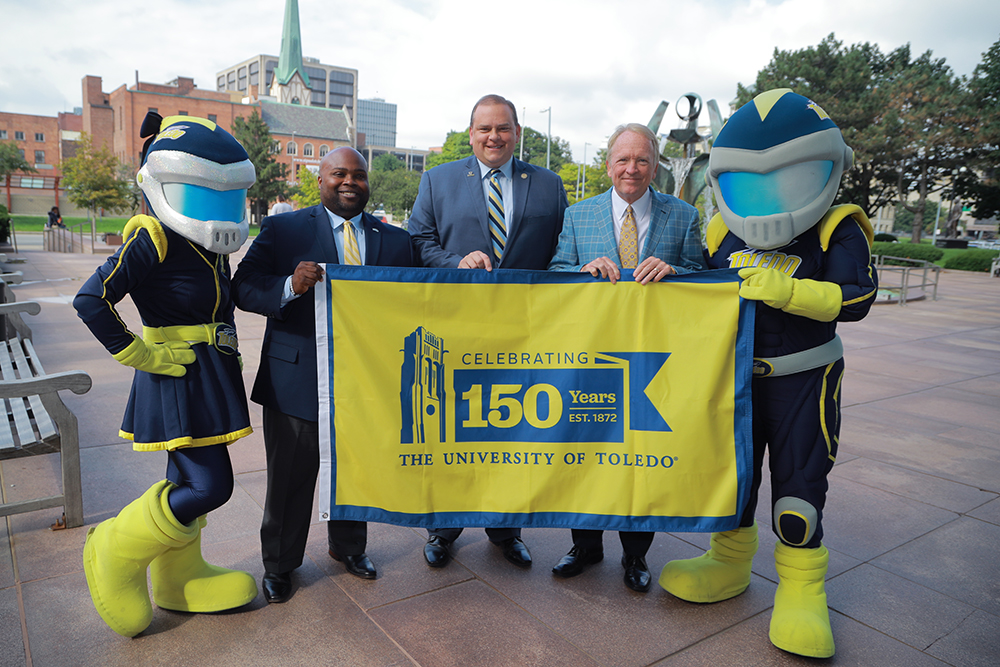 City of Toledo Mayor Wade Kapszukiewicz and University of Toledo President Dr. Gregory Postel hold the flag representing the University's sesquicentennial