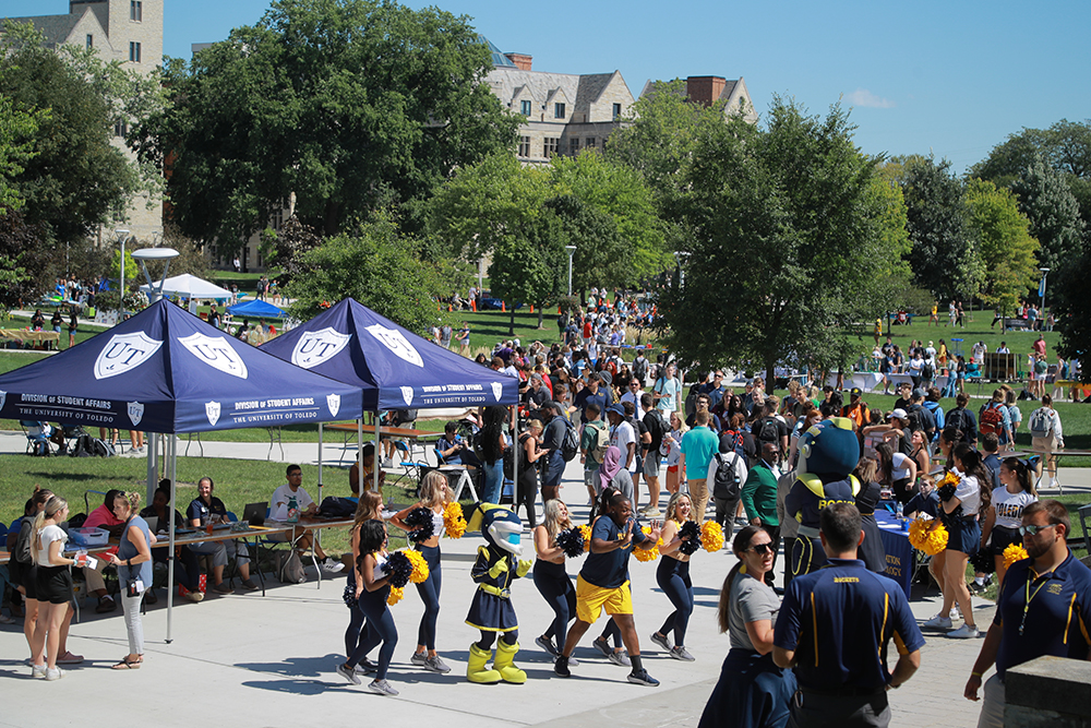 A big crowd of students, faculty and staff walking through Centennial Mall during a pep rally