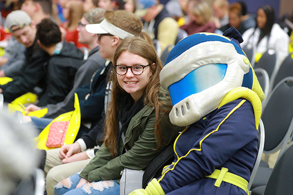 Rockys and a student sitting and posing for a picture at an admission event