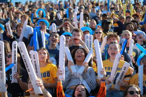students cheering in stands at a football game