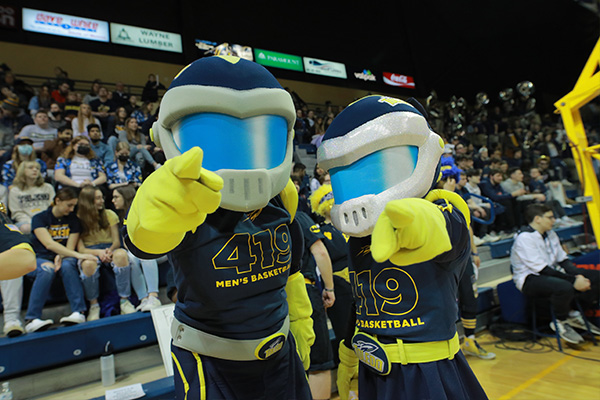 Rocky and Rocksy in a basketball arena, pointing at the camera