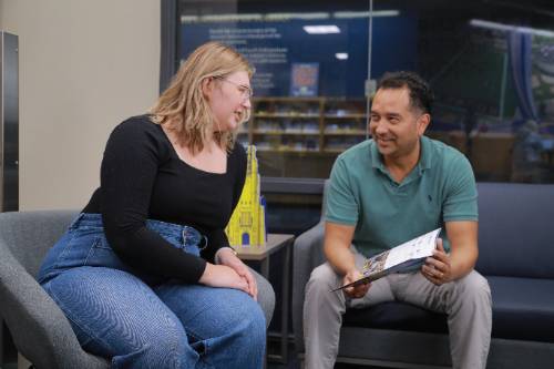 student talking to an admission counselor in an office