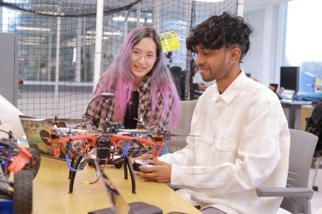students in a classroom working with a drone