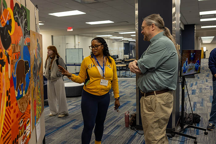 student showing work at undergraduate research program