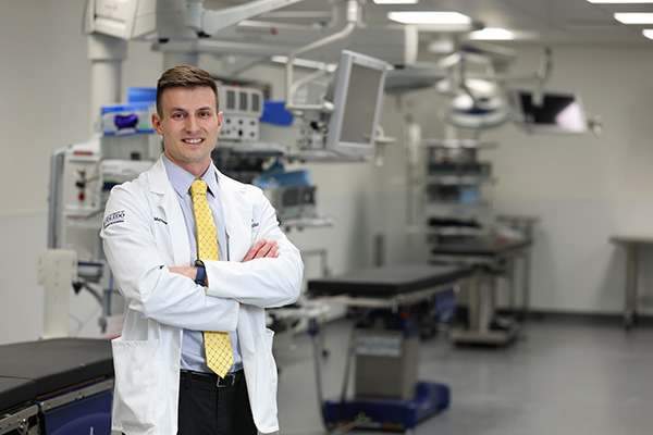 Medical student standing in front of medical equipment