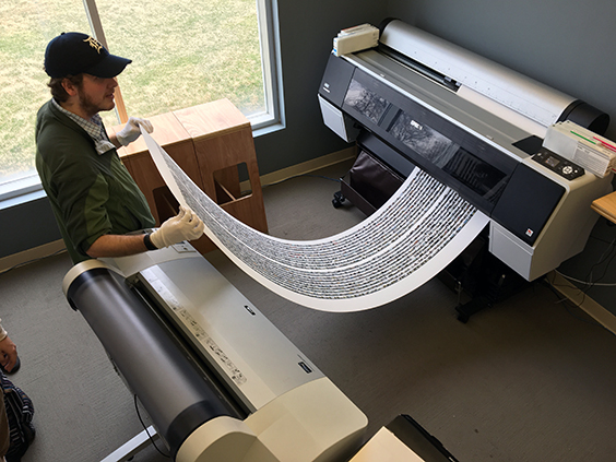 Student retrieving print from large format Epson printer.