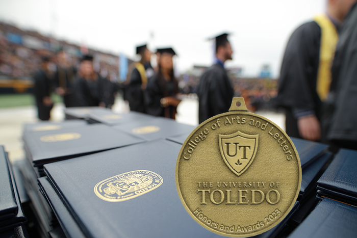 CAL commencement with students marching past table with diploma cases Dean's Medal in foreground