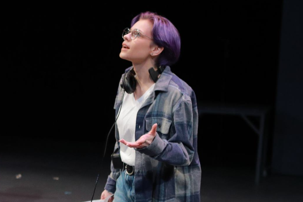 Actor onstage with a document in hand