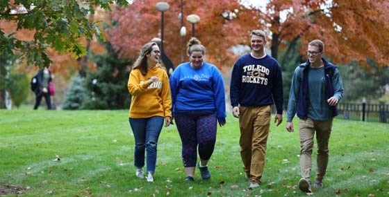 Students walking across campus in the fall