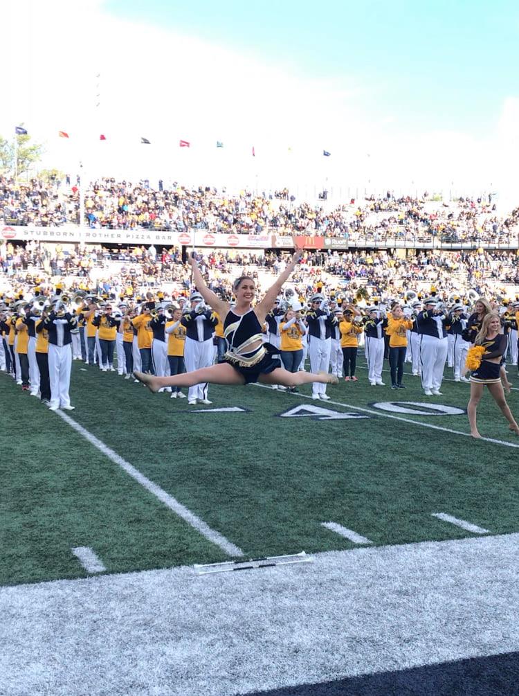 majorette leaping on football field