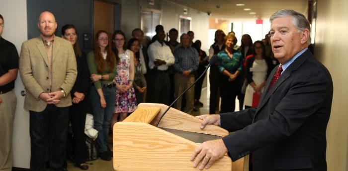 Alan Barry standing at a podium talking to a group of people