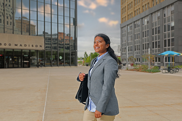 a female college of business student walking in down town toledo dressed in business professional attire