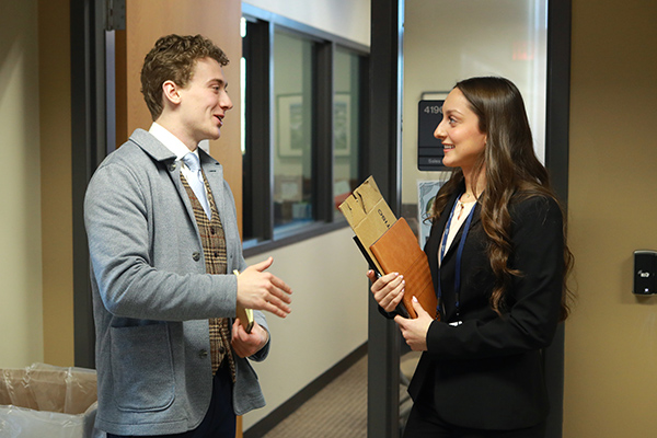 a business student talking to mock interviewer in an academic bulding