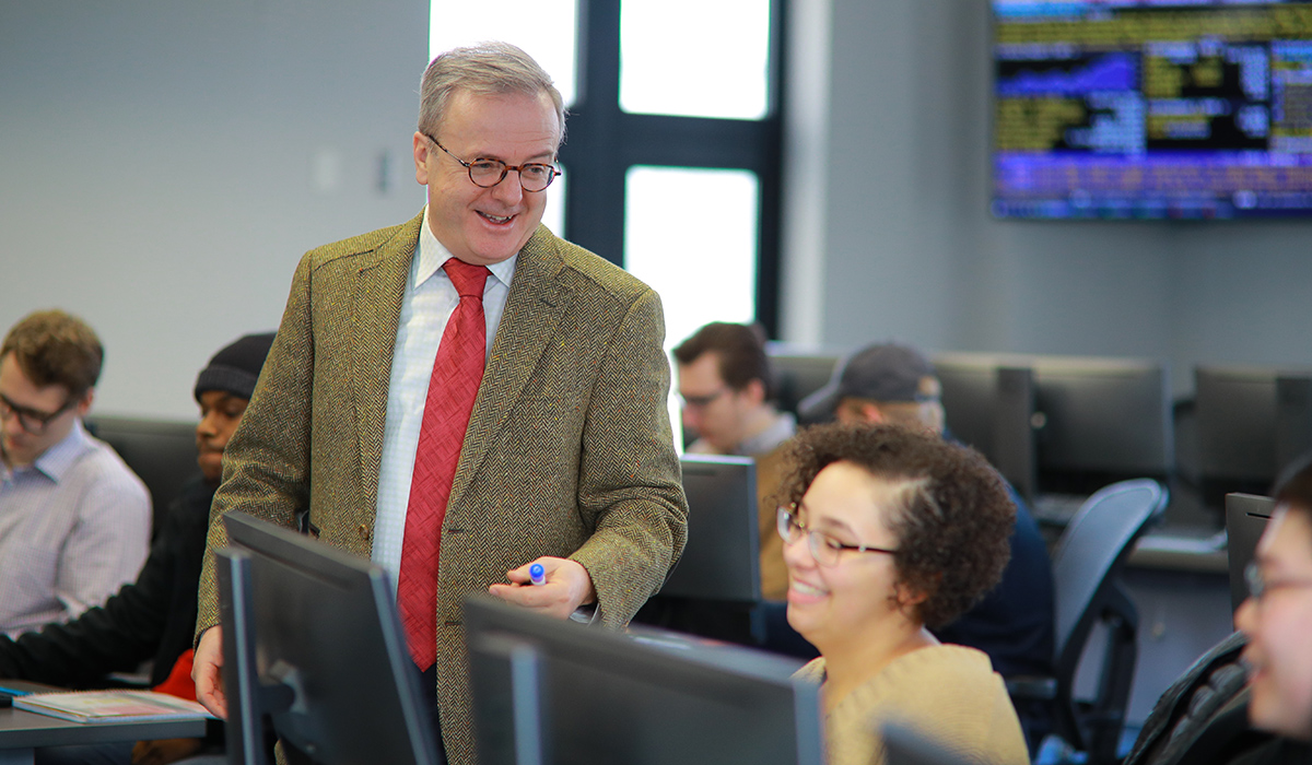 Neff College of Business Associate Professor Ozcan Sezer talking to business students in the neff trading room 