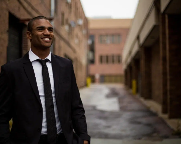 Young business professional standing in an alley with a suit on 