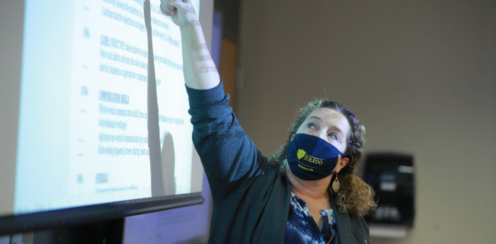 A woman giving a presentation to a class of students