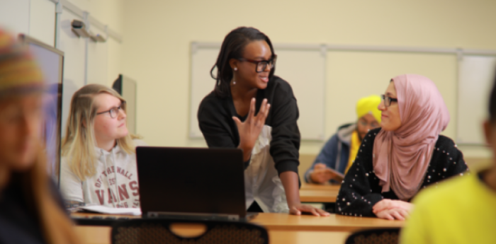 A woman giving a presentation to a class of students