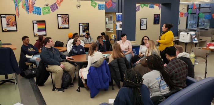 A woman giving a presentation to a class of students