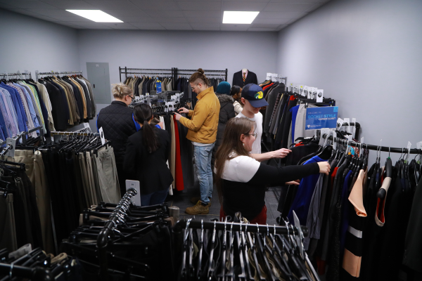 Photo of students shopping in Rocket Style and browsing racks of professional clothing