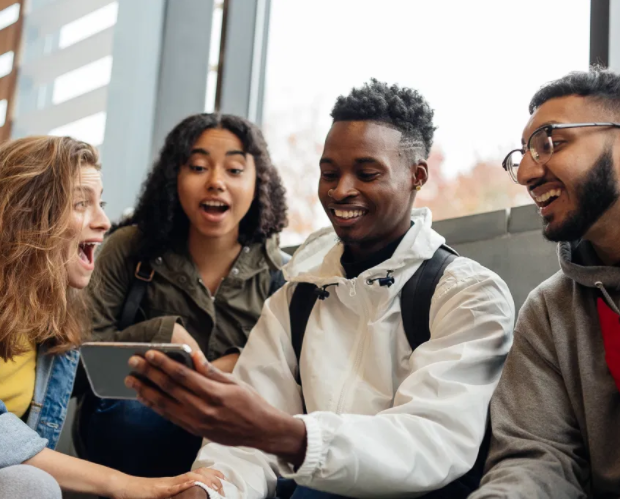 group of multicultural students view website on mobile device