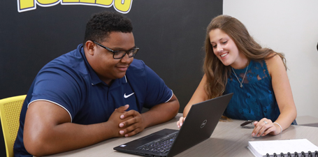Student working with a career ambassador on a computer looking for jobs