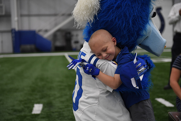 Child getting a hug from a mascot