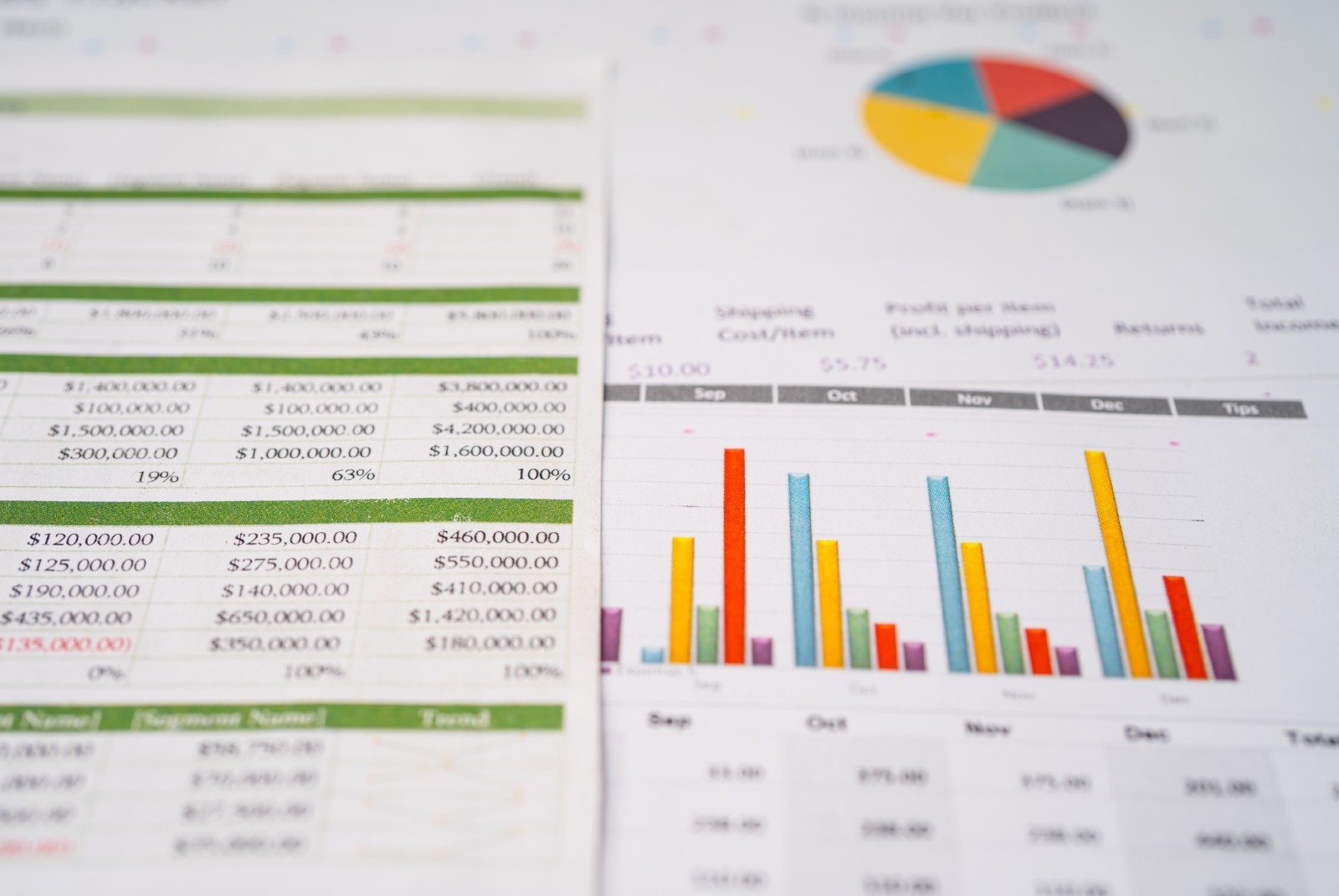 Two sheets of paper, one showing numbers in a spreadsheet and one showing different graphs