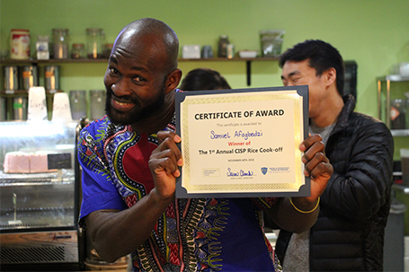 student posing with certificate for first place in rice cook-off