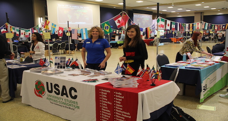 2 females standing behind a table at an informatin fair