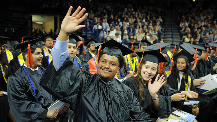 engineering student waving at spring commencement ceremony