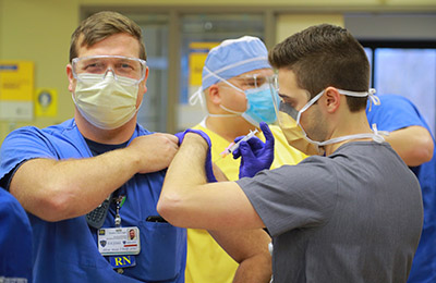 male-nurse-receiving-covid-vaccine