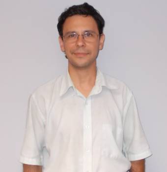 smiling man with glasses in white shirt and blue tie