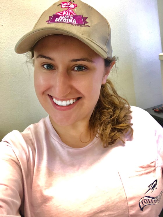 smiling blond woman in owens corning pink panther baseball hat